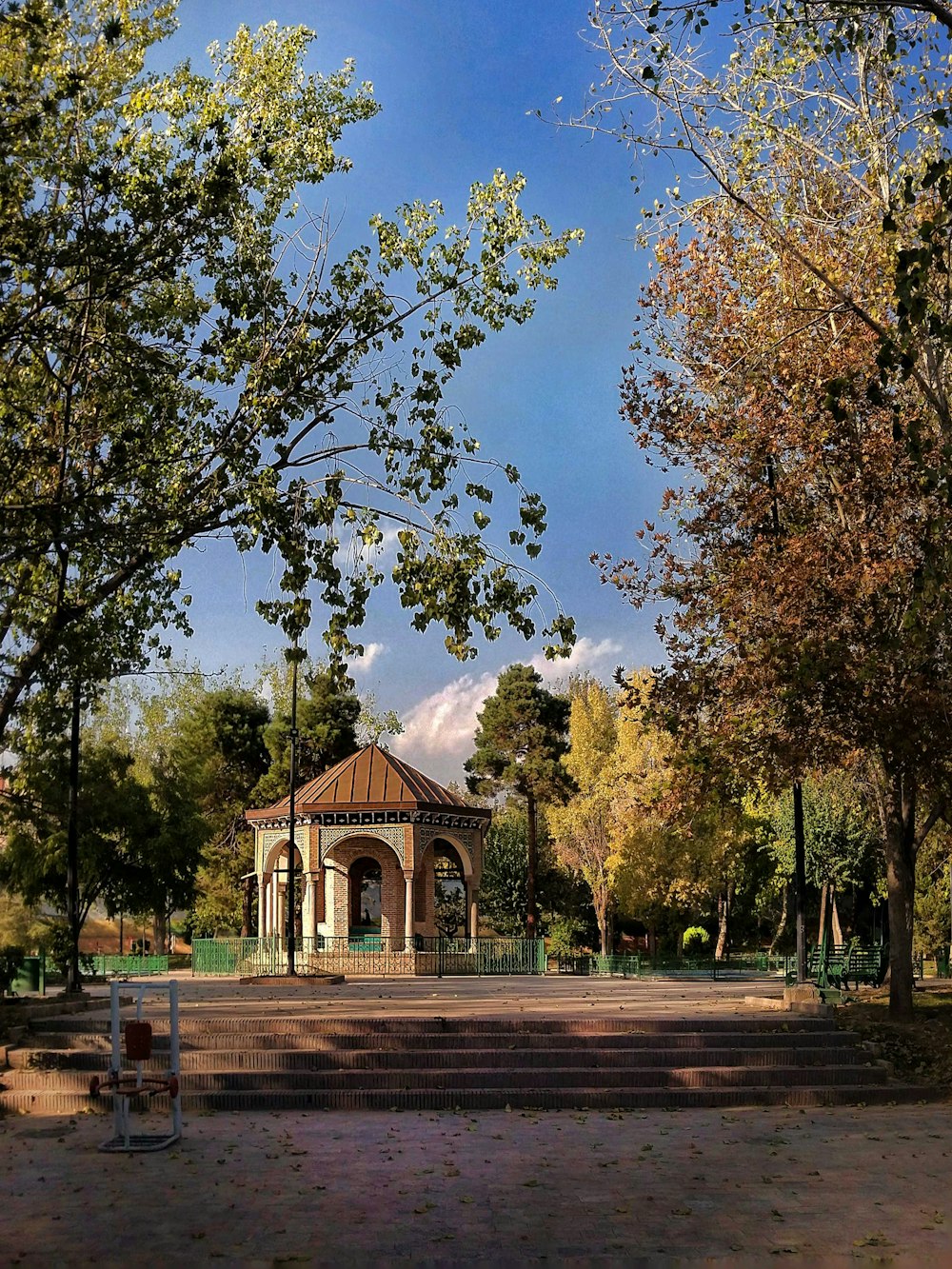 ein Pavillon mitten in einem Park, der von Bäumen umgeben ist