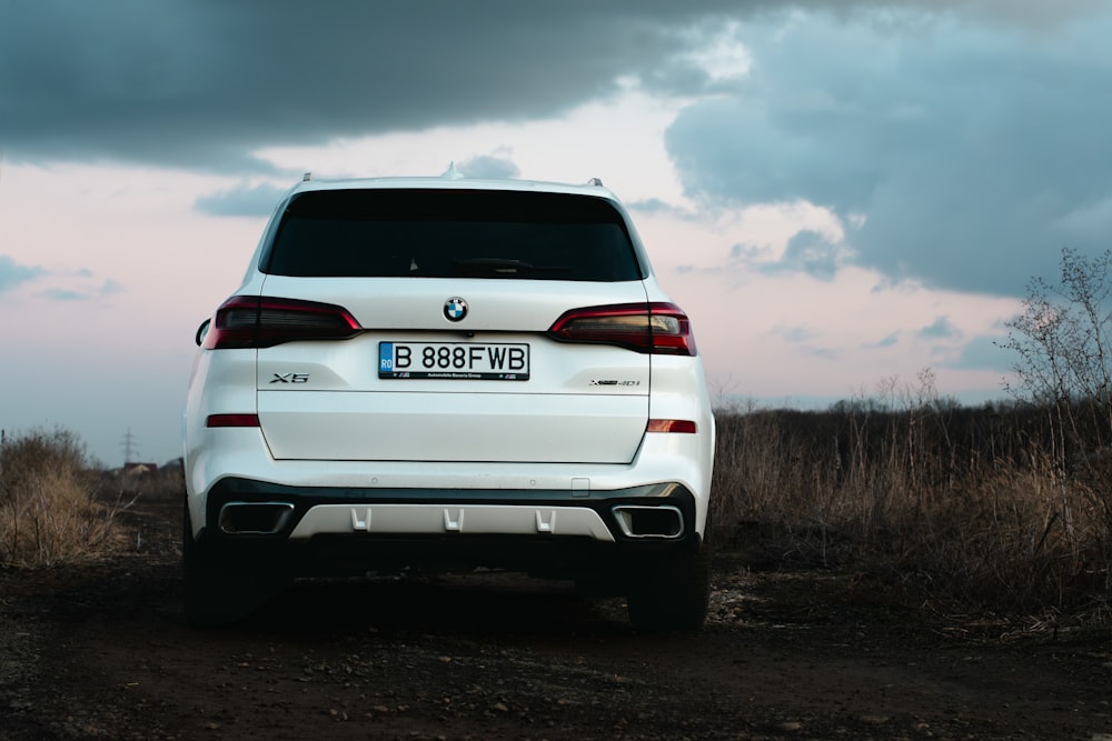 a white car parked on a dirt road