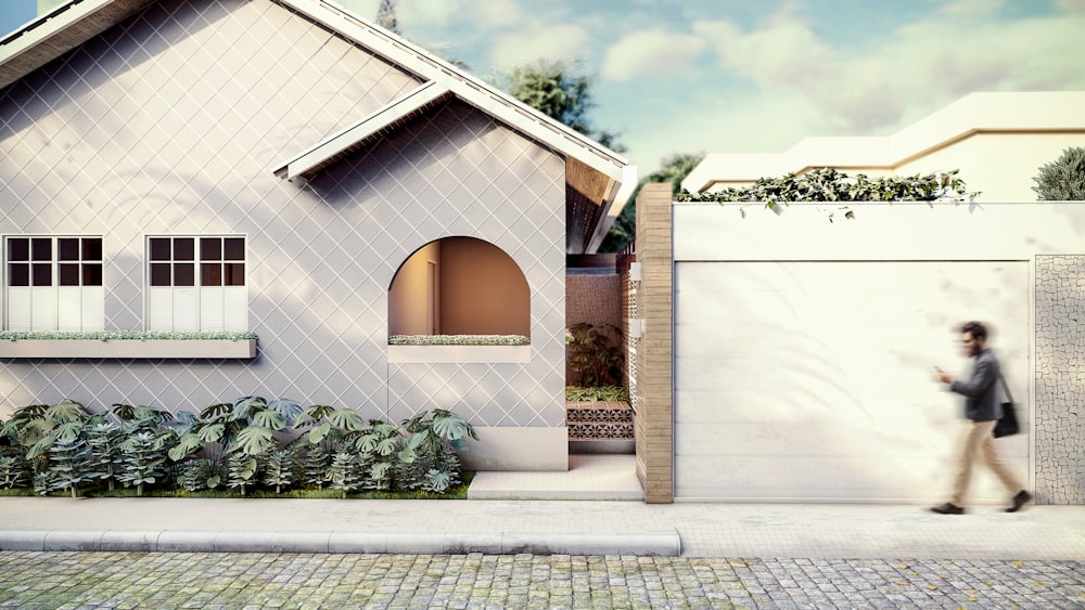 a person walking past a house with a white fence