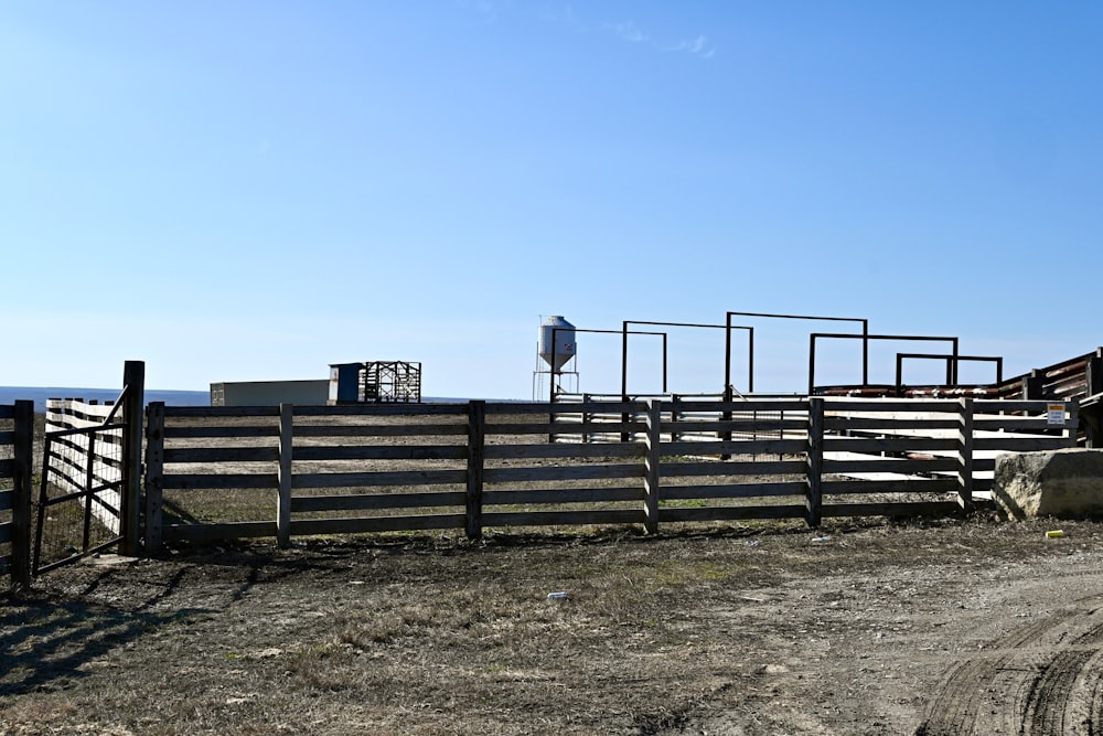 a fenced in area next to a dirt road