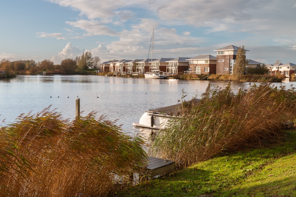 a boat sits on the water near a row of houses