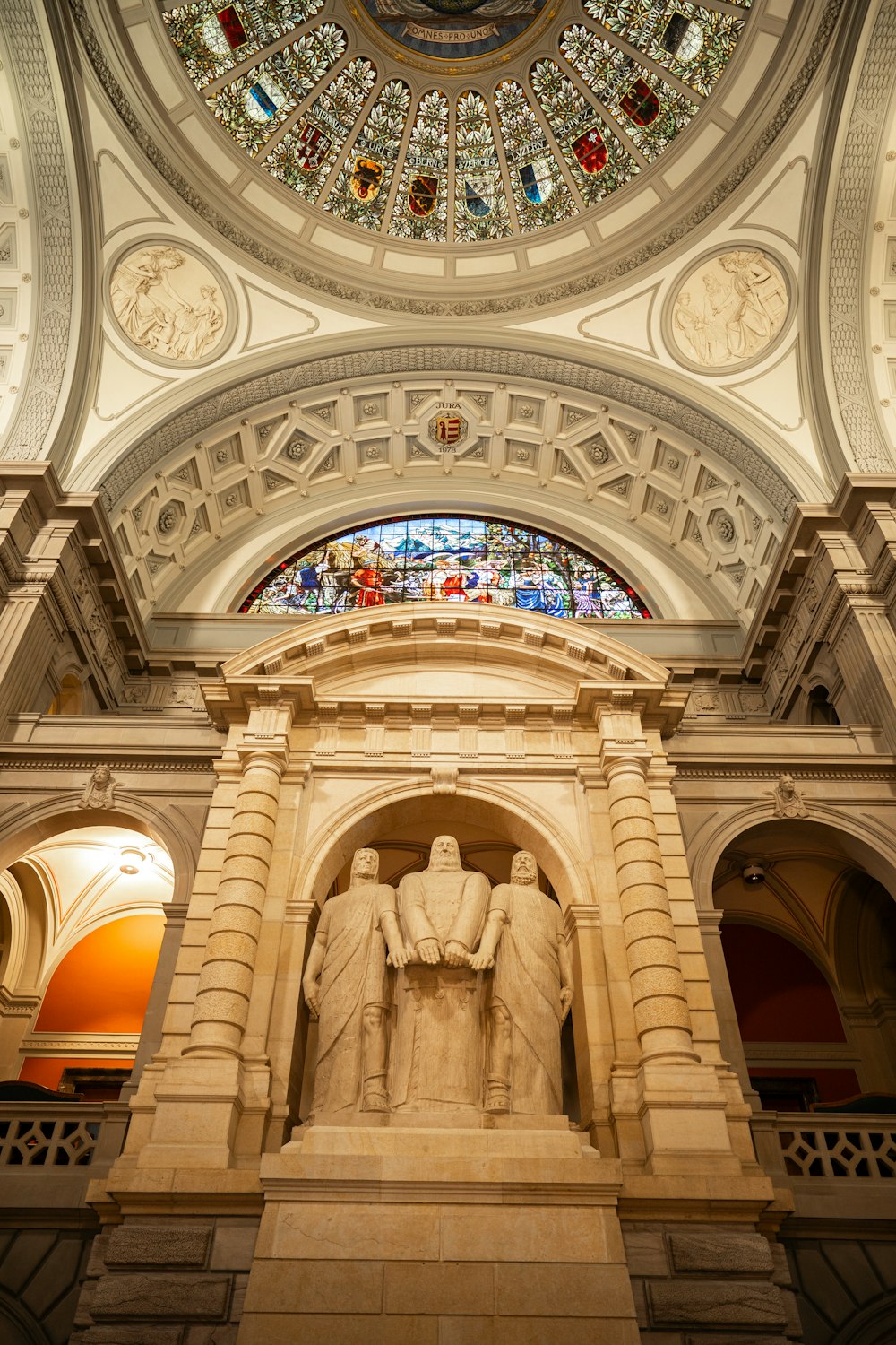 a statue of a man and a woman under a stained glass dome