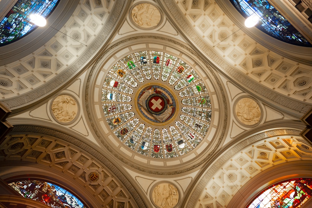 the ceiling of a church with stained glass windows