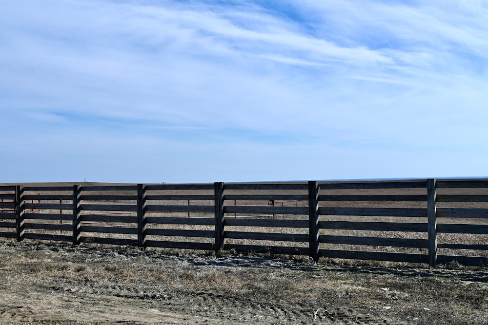 a wooden fence in the middle of a field