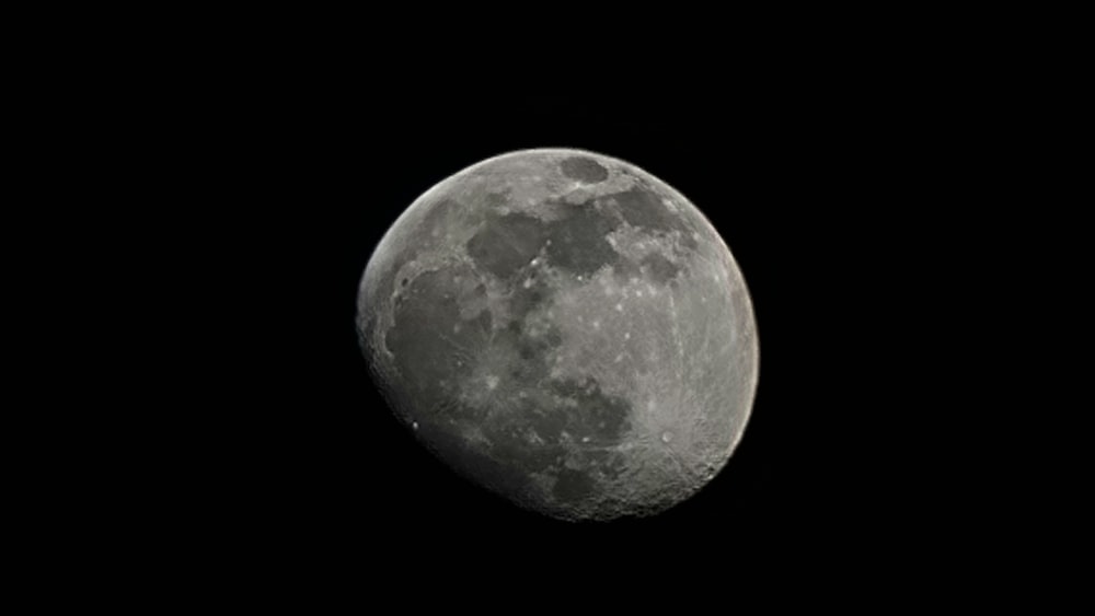 a full moon in the sky with a black background