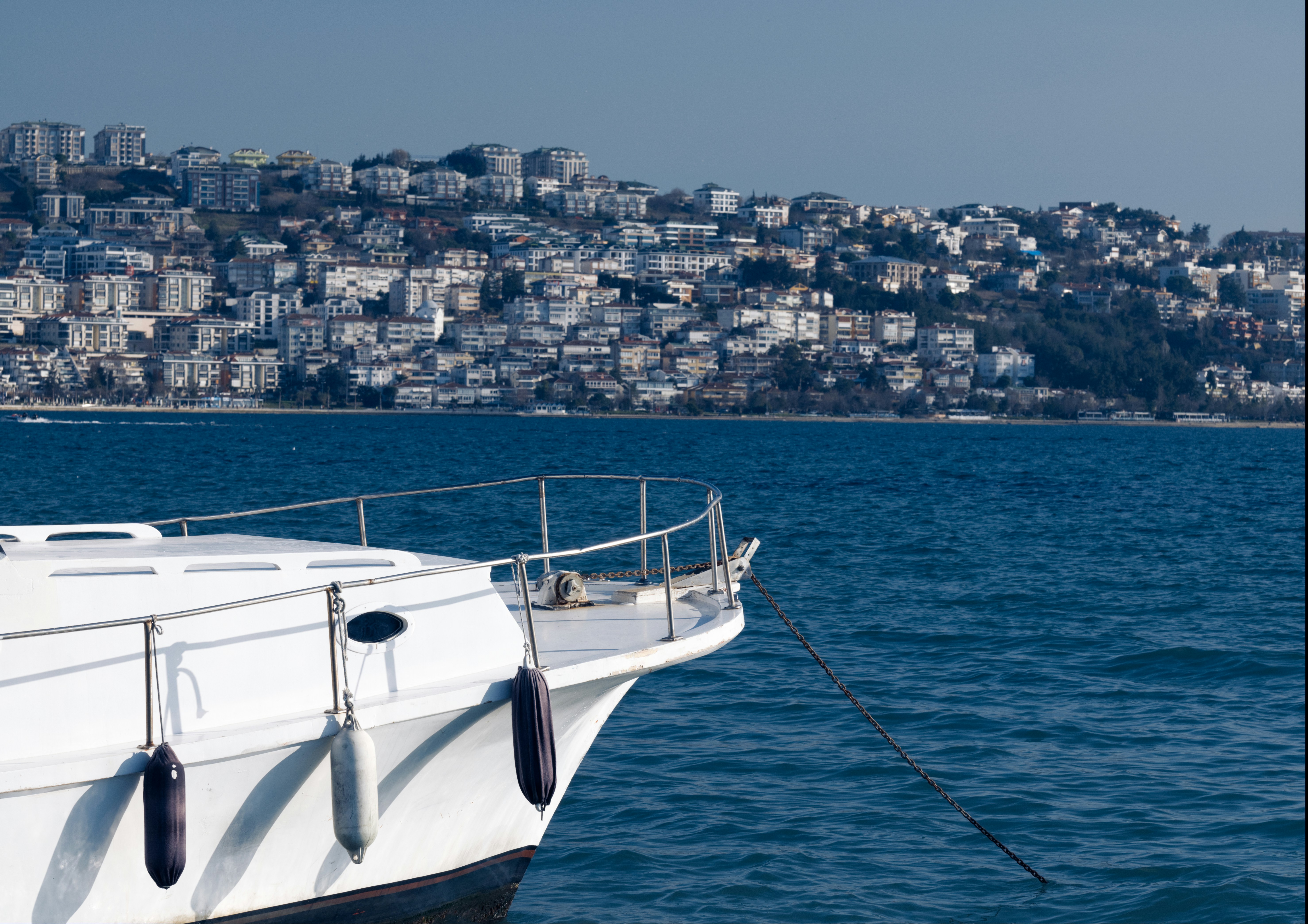 una barca bianca nell'acqua con una città sullo sfondo