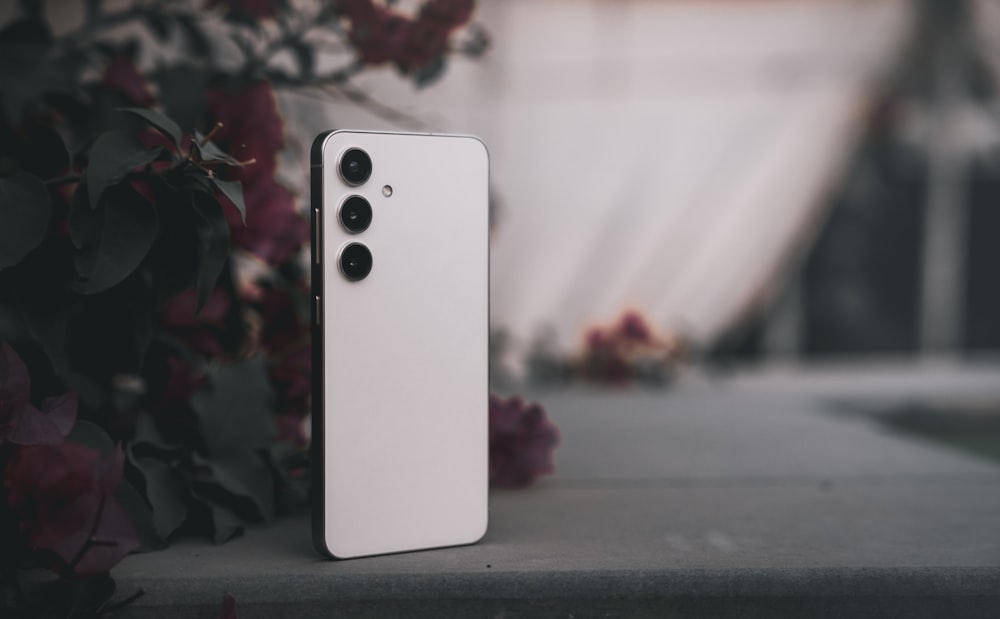 a white cell phone sitting on top of a table