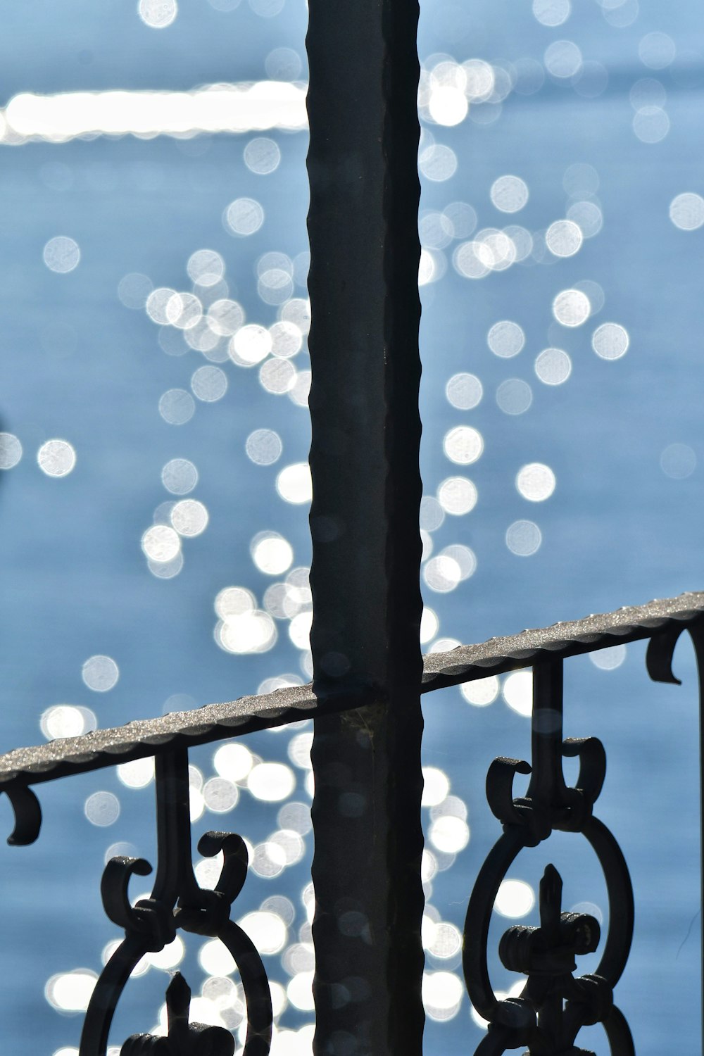 a close up of a railing with water in the background