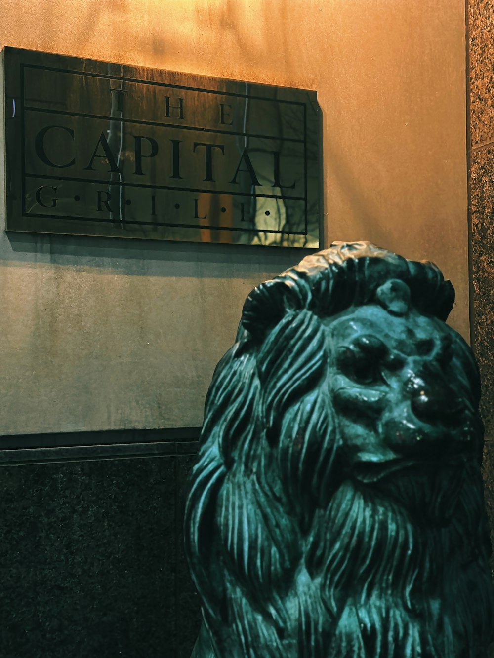 a statue of a lion in front of a sign