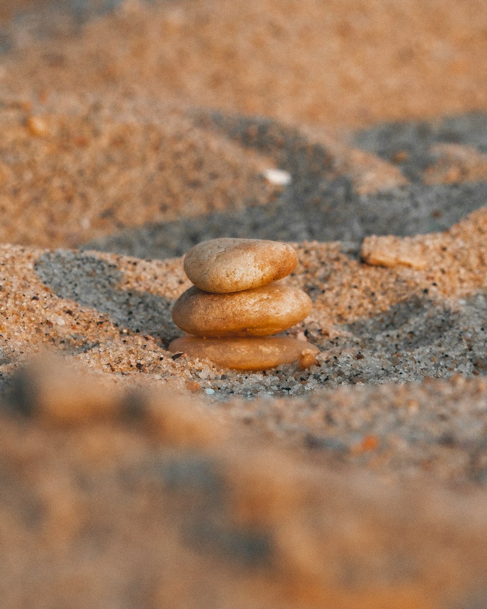 a pile of rocks sitting on top of a sandy beach