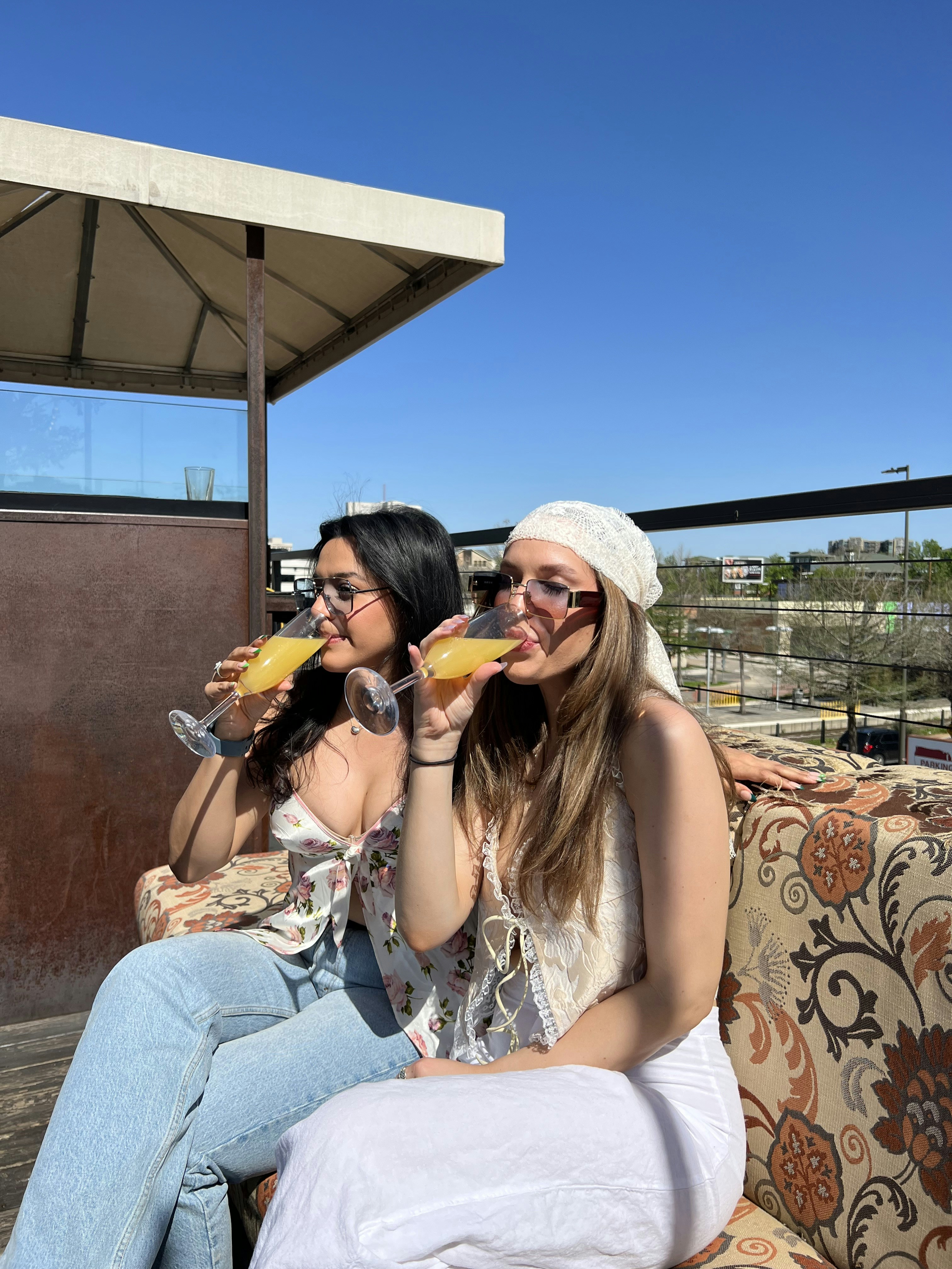 zwei Frauen sitzen auf einer Couch und trinken Wein