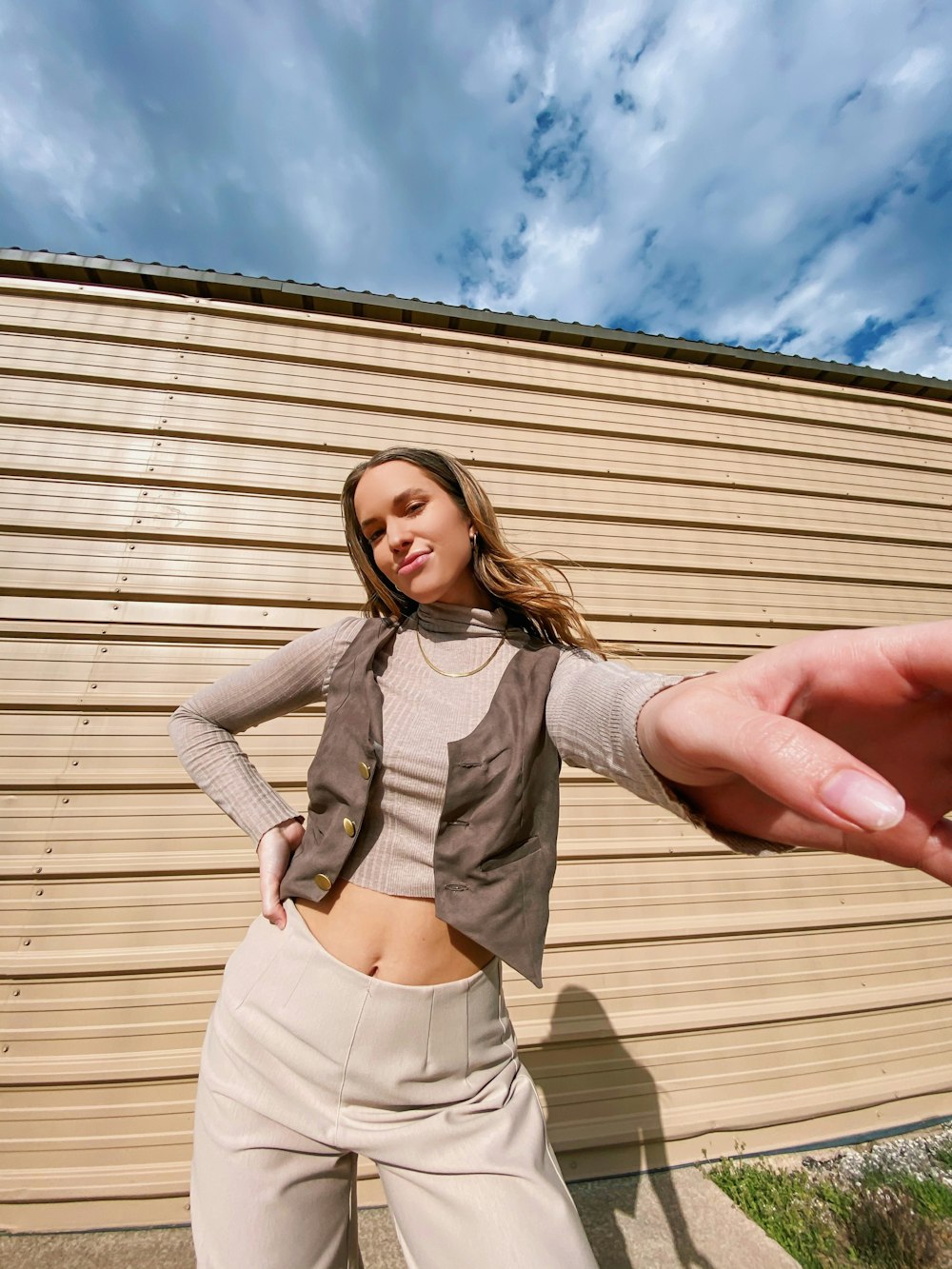 a woman holding her hand out in front of a building