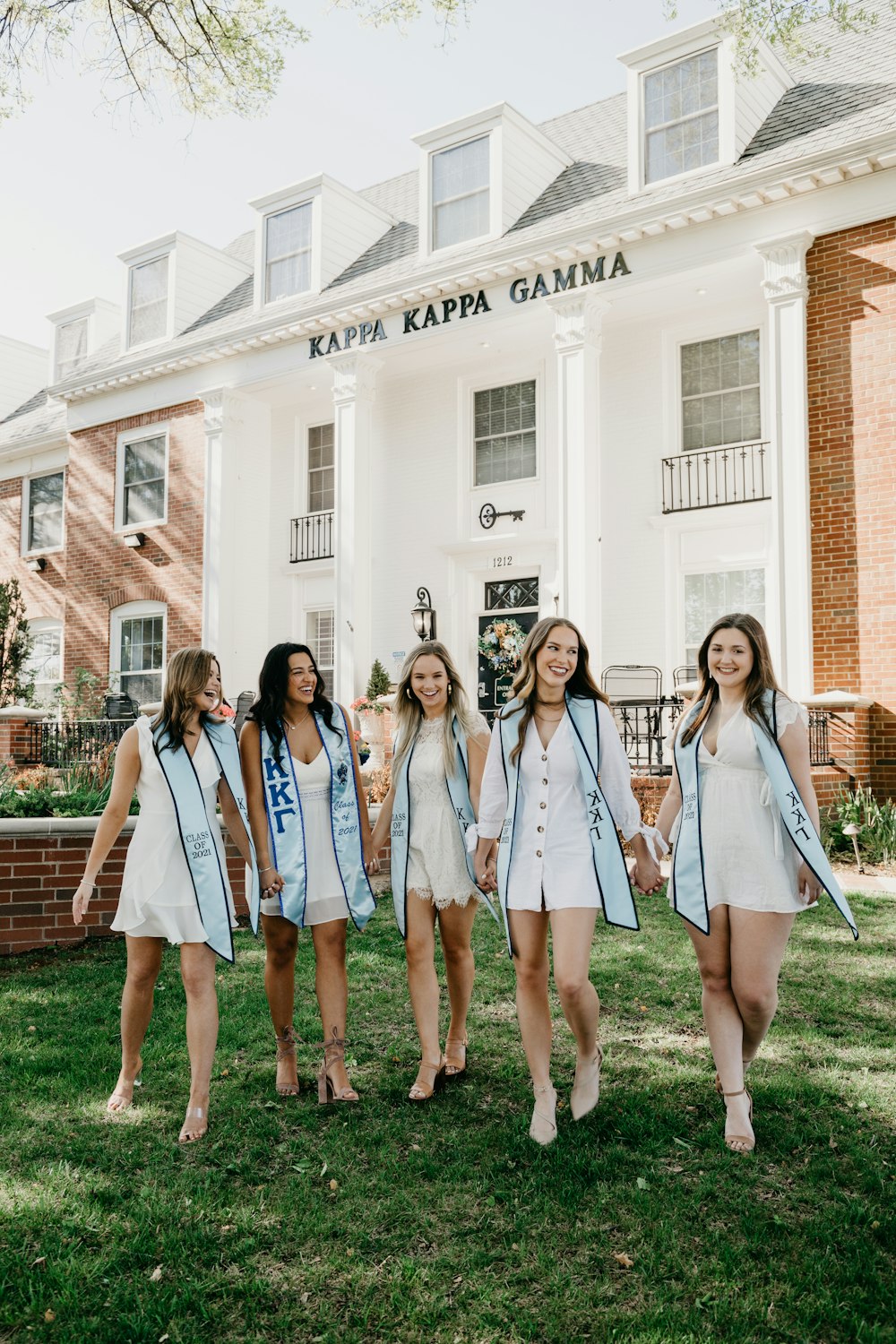 a group of young women standing next to each other in front of a building