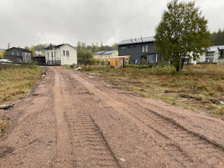 a gravel road in front of a row of houses