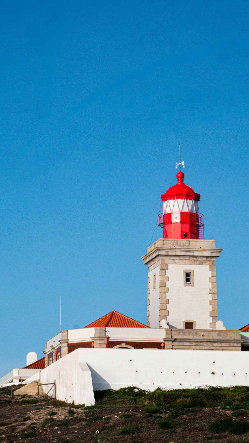 a red and white light house on top of a hill