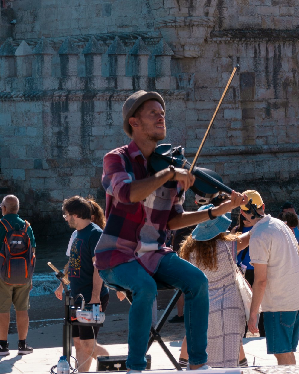 a man sitting on a chair playing a violin