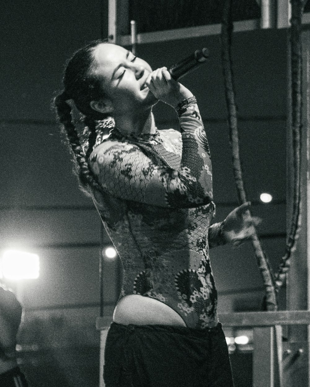 Une femme chante dans un micro sur une photo en noir et blanc