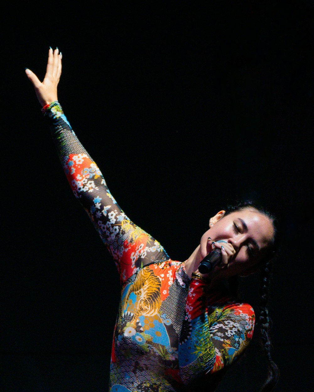 a woman in a colorful outfit holding a microphone