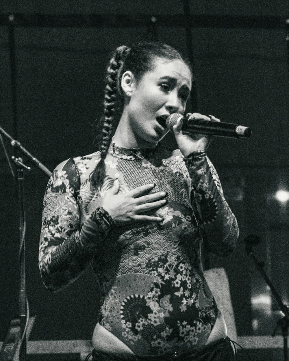 a woman singing into a microphone on stage