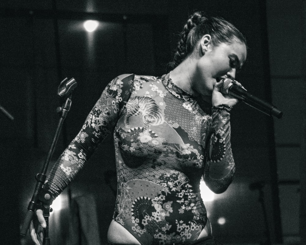 una mujer en traje cantando en un micrófono