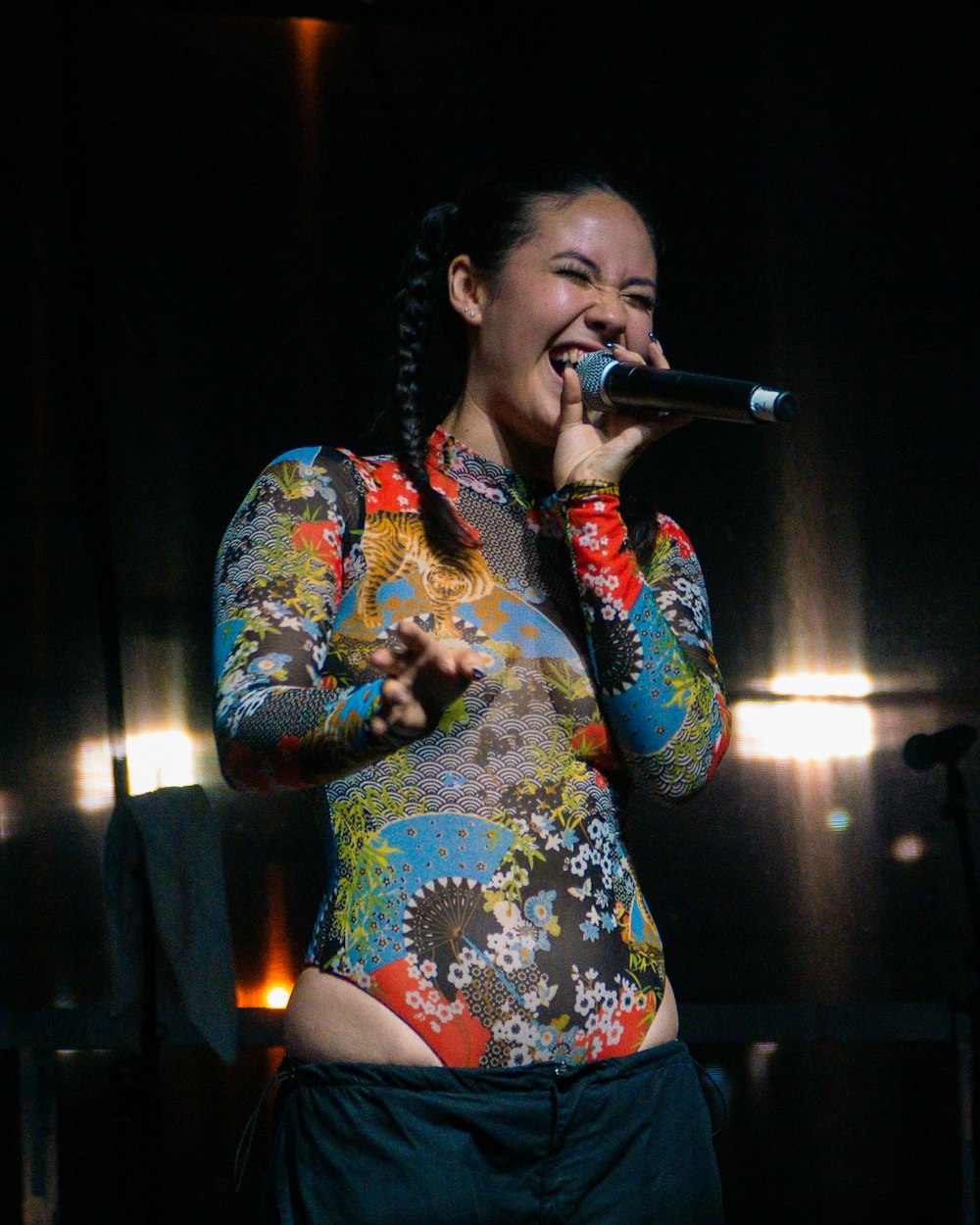 a woman singing into a microphone on stage