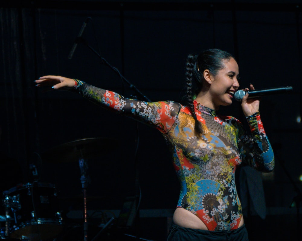 una mujer en traje cantando en un micrófono