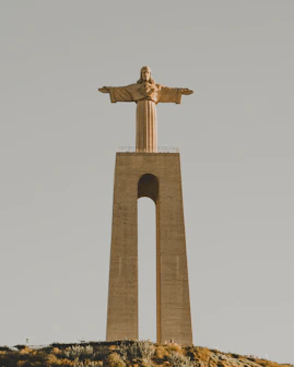 a statue of jesus on top of a hill