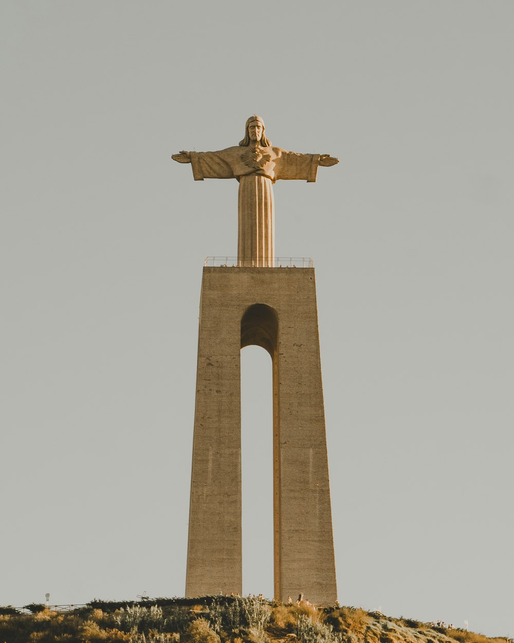 a statue of jesus on top of a hill