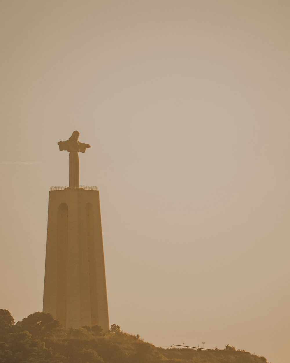 a statue on top of a hill with a sky background