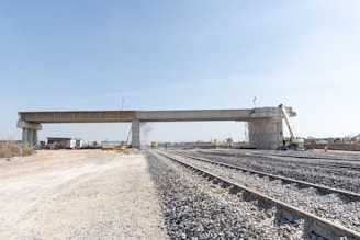 a train track with a bridge in the background