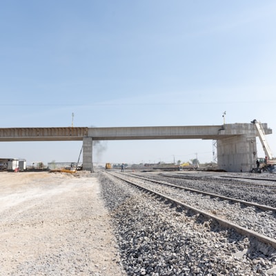 a train track with a bridge in the background