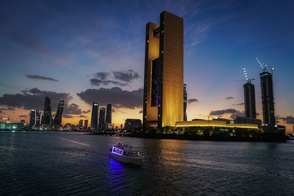 a boat in a body of water near a tall building