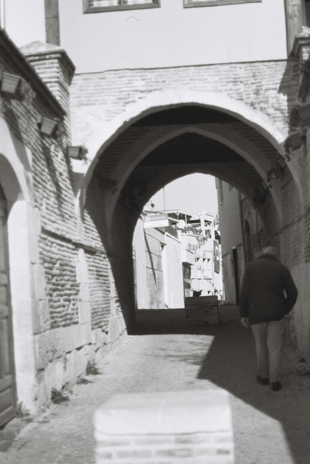 a person walking down a narrow alley way