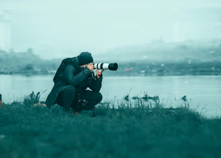a photographer taking a picture of a body of water