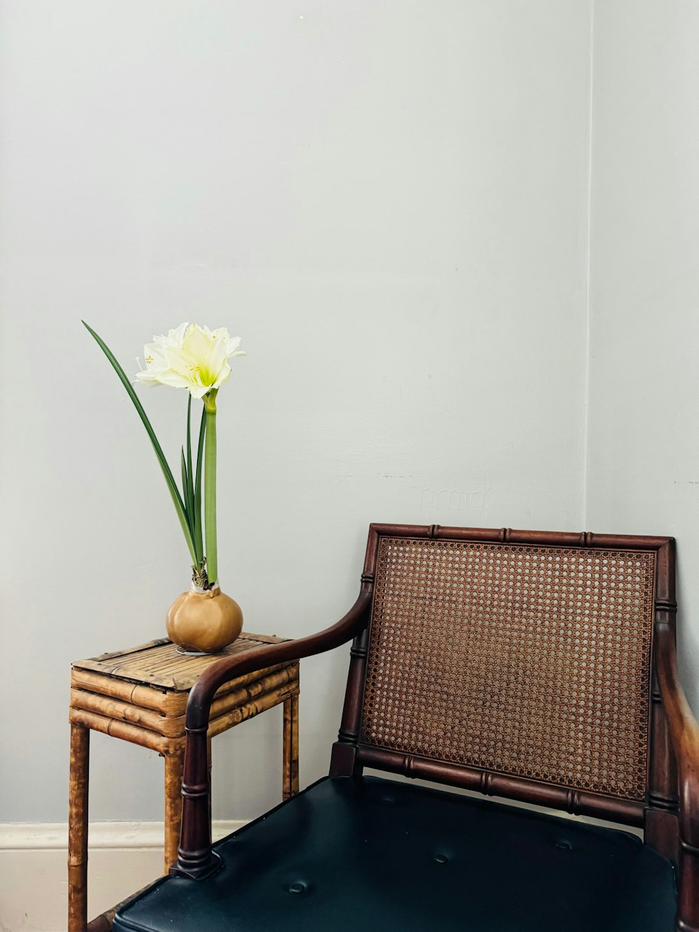 a chair and a vase with a flower on it