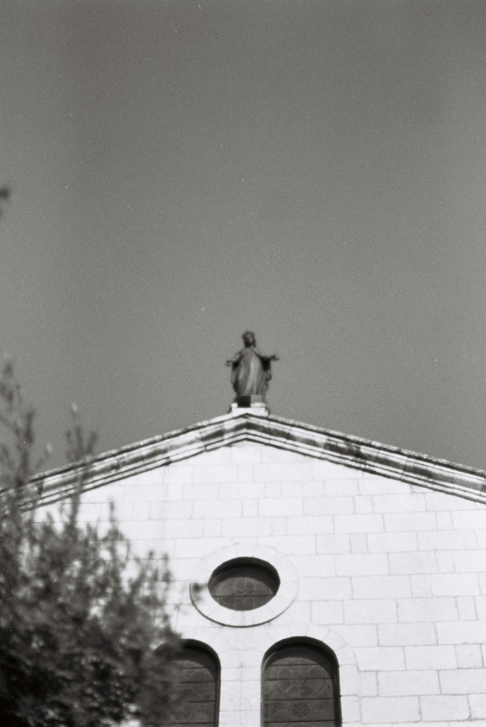 a black and white photo of a building with a statue on top