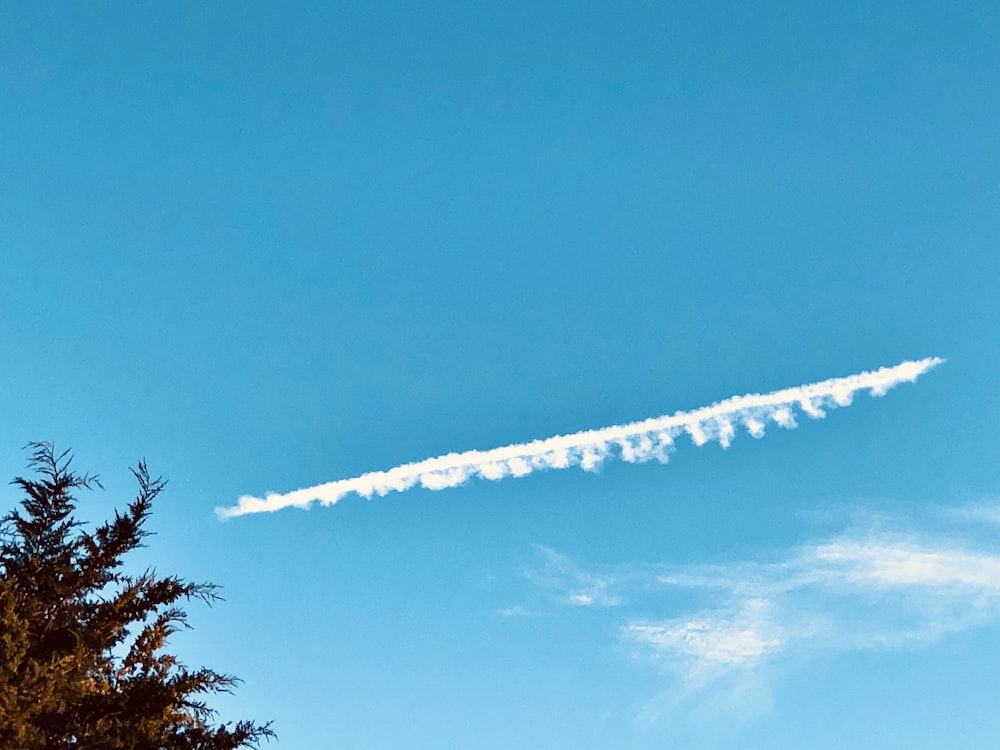 a contrail is flying in the blue sky