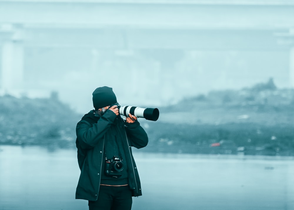 a person taking a picture with a camera on a foggy day