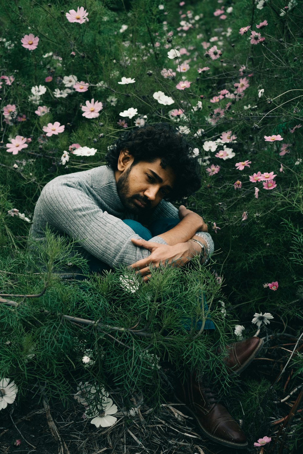 a man sitting in a field of flowers