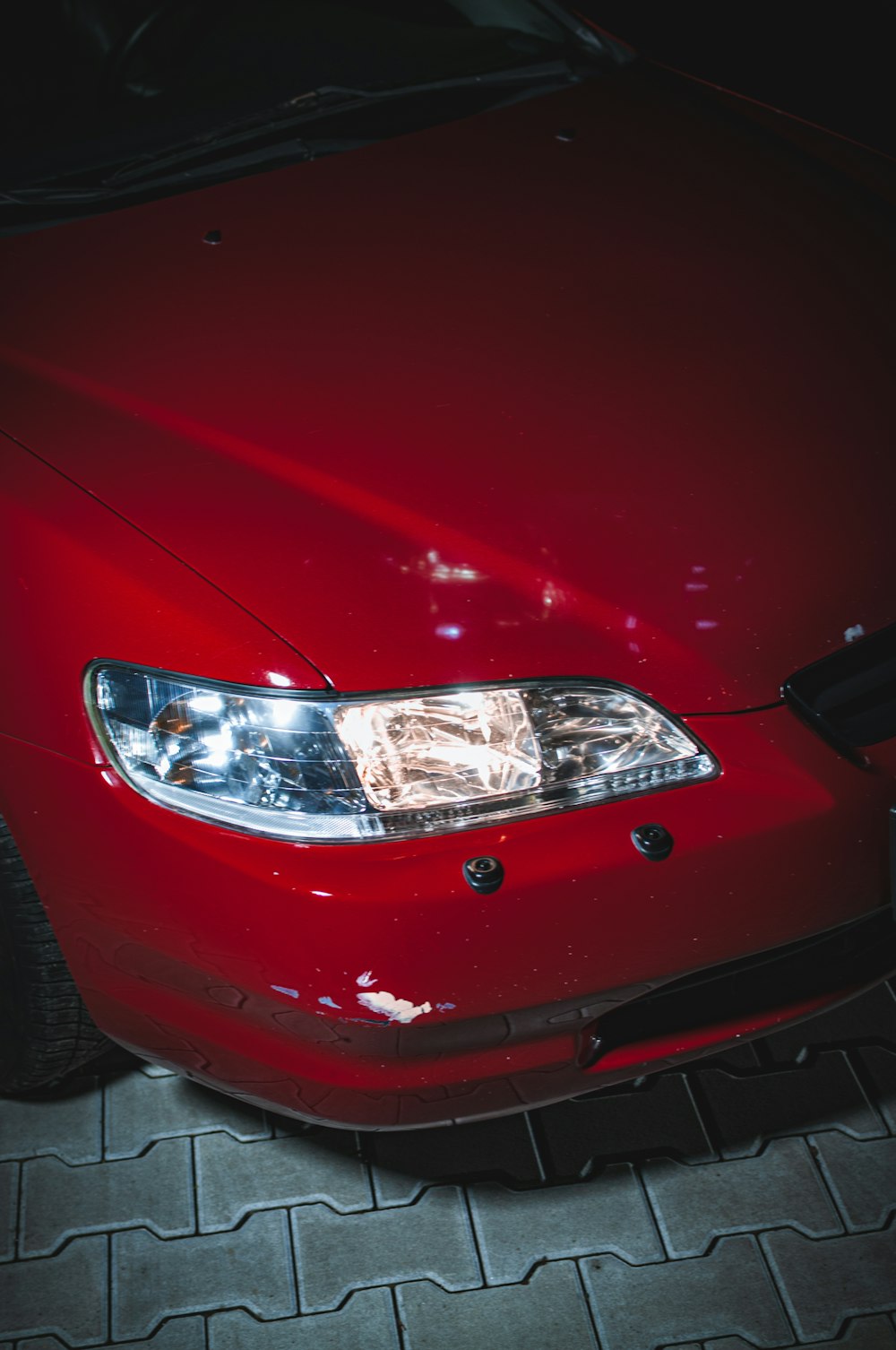 a close up of a red car on a tile floor