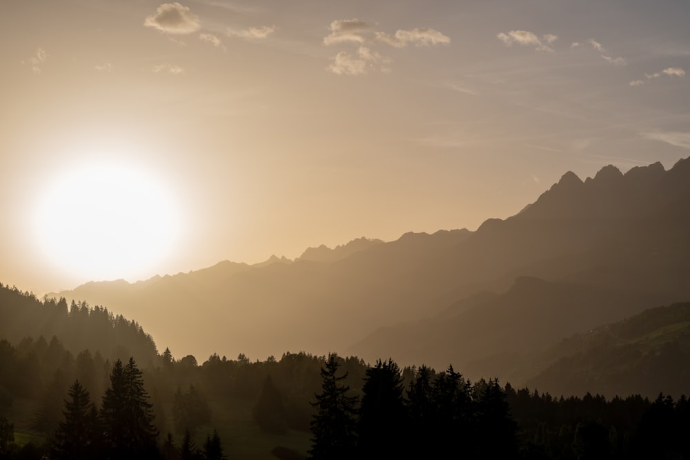 the sun is setting over a mountain range