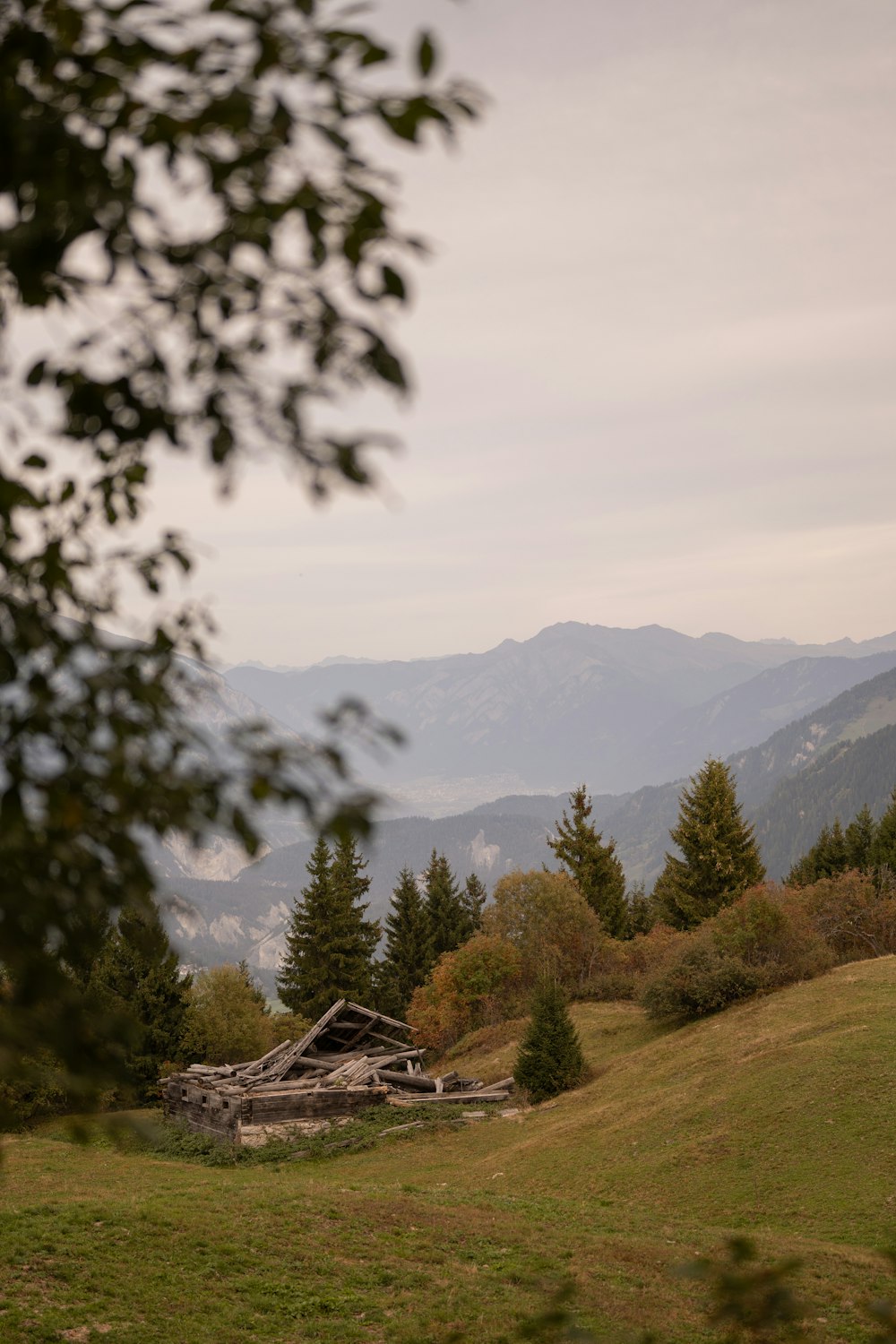 a view of a mountain range with a barn in the foreground