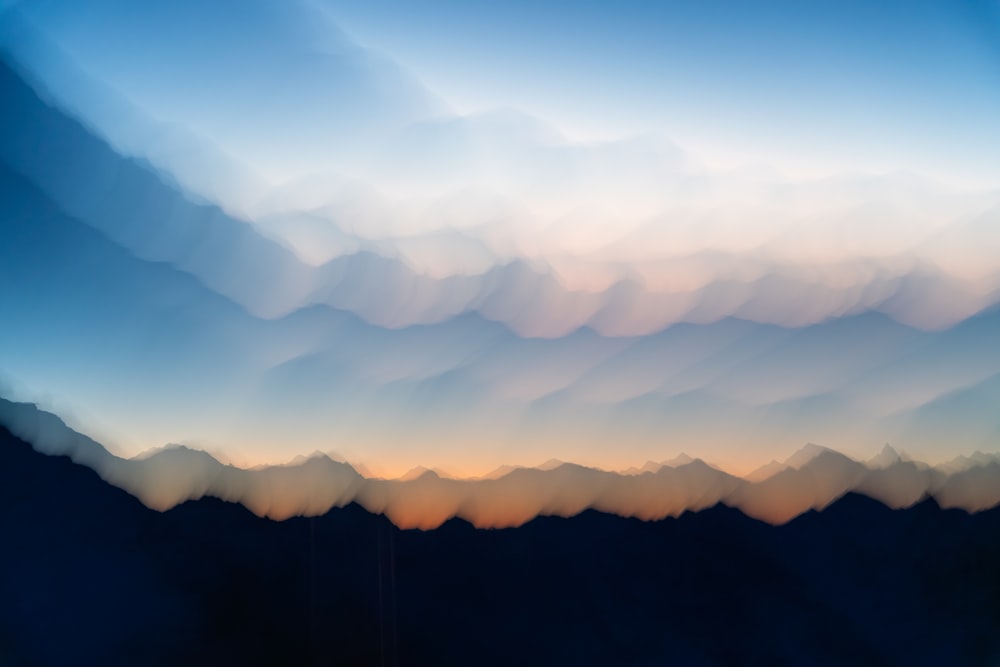 a blurry photo of a mountain range at sunset
