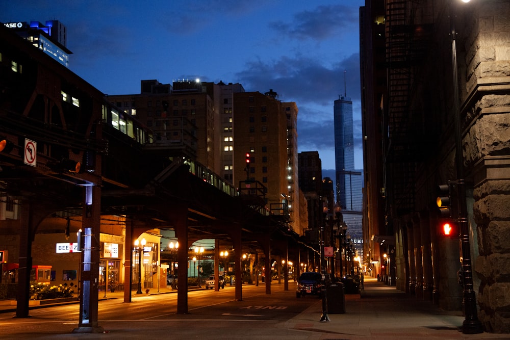 a city street at night with tall buildings