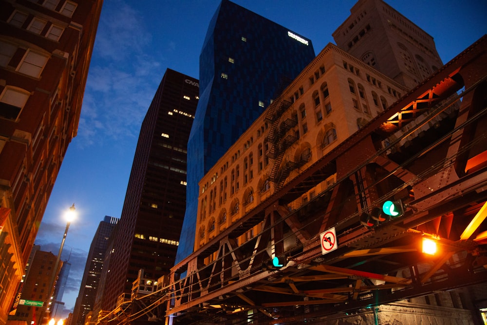 a city street at night with traffic lights and a bridge