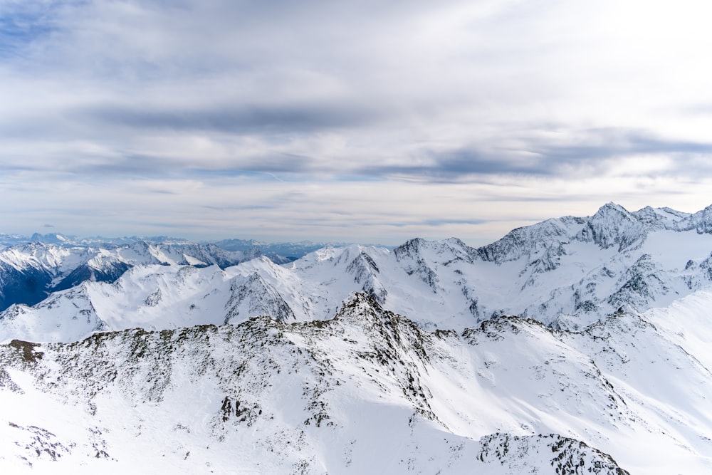 a view of a snowy mountain range from the top of a mountain