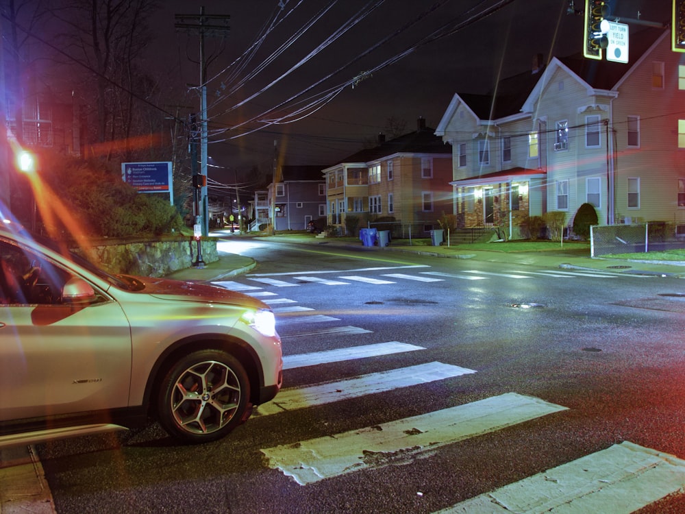 a car is stopped at an intersection at night