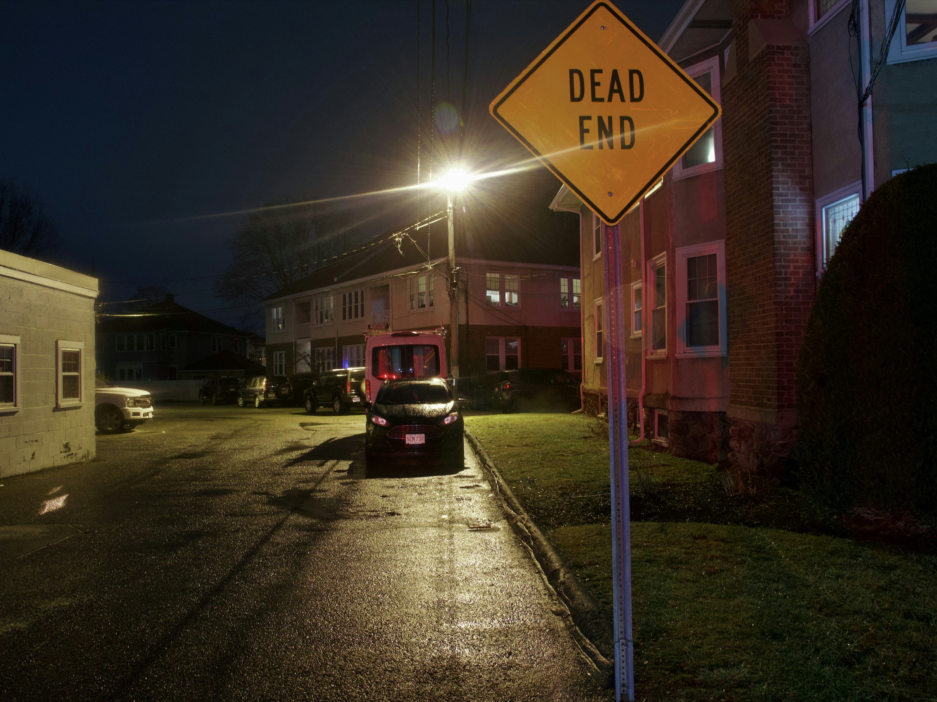a yellow dead end sign sitting on the side of a road