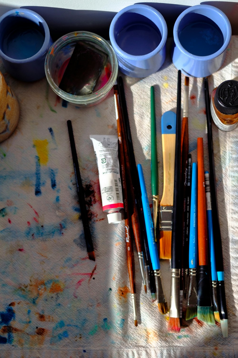 a table topped with lots of paint and brushes