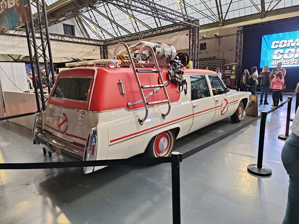 a red and white car with luggage on top of it